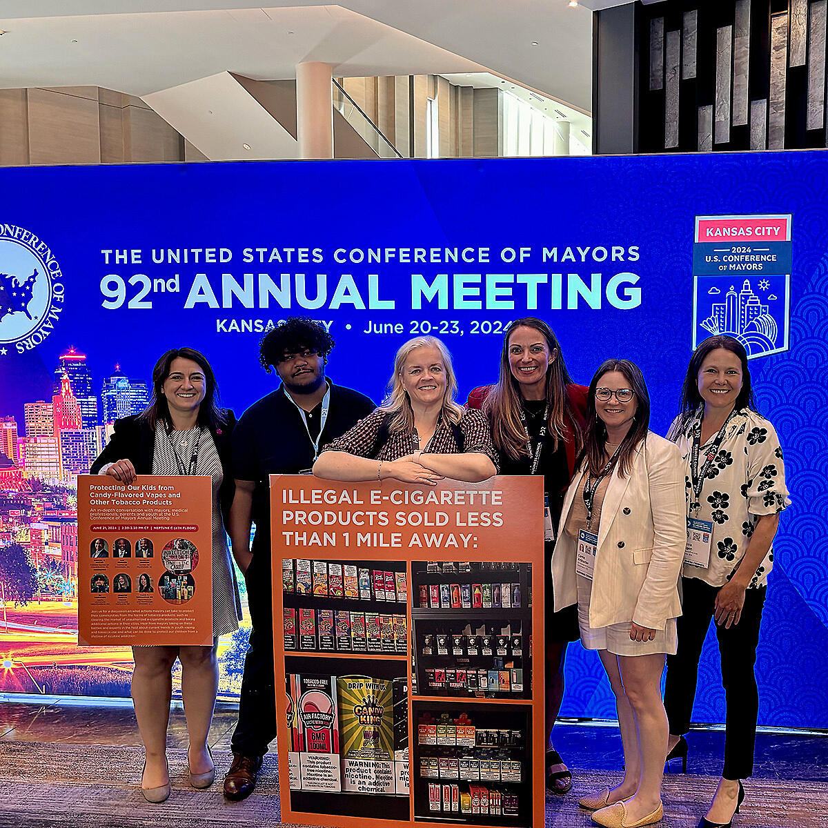 TFK staff pose with signs at conference.