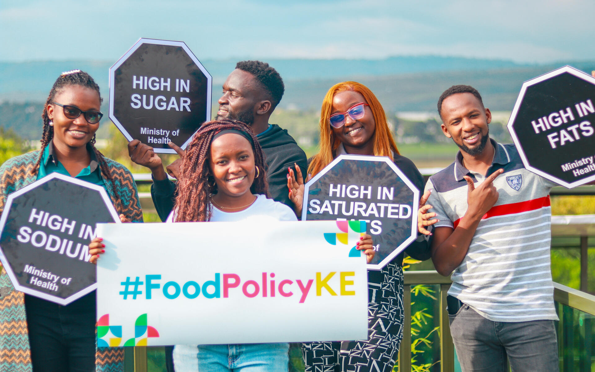 Journalists and advocates from the Food Policy Kenya movement hold signs.
